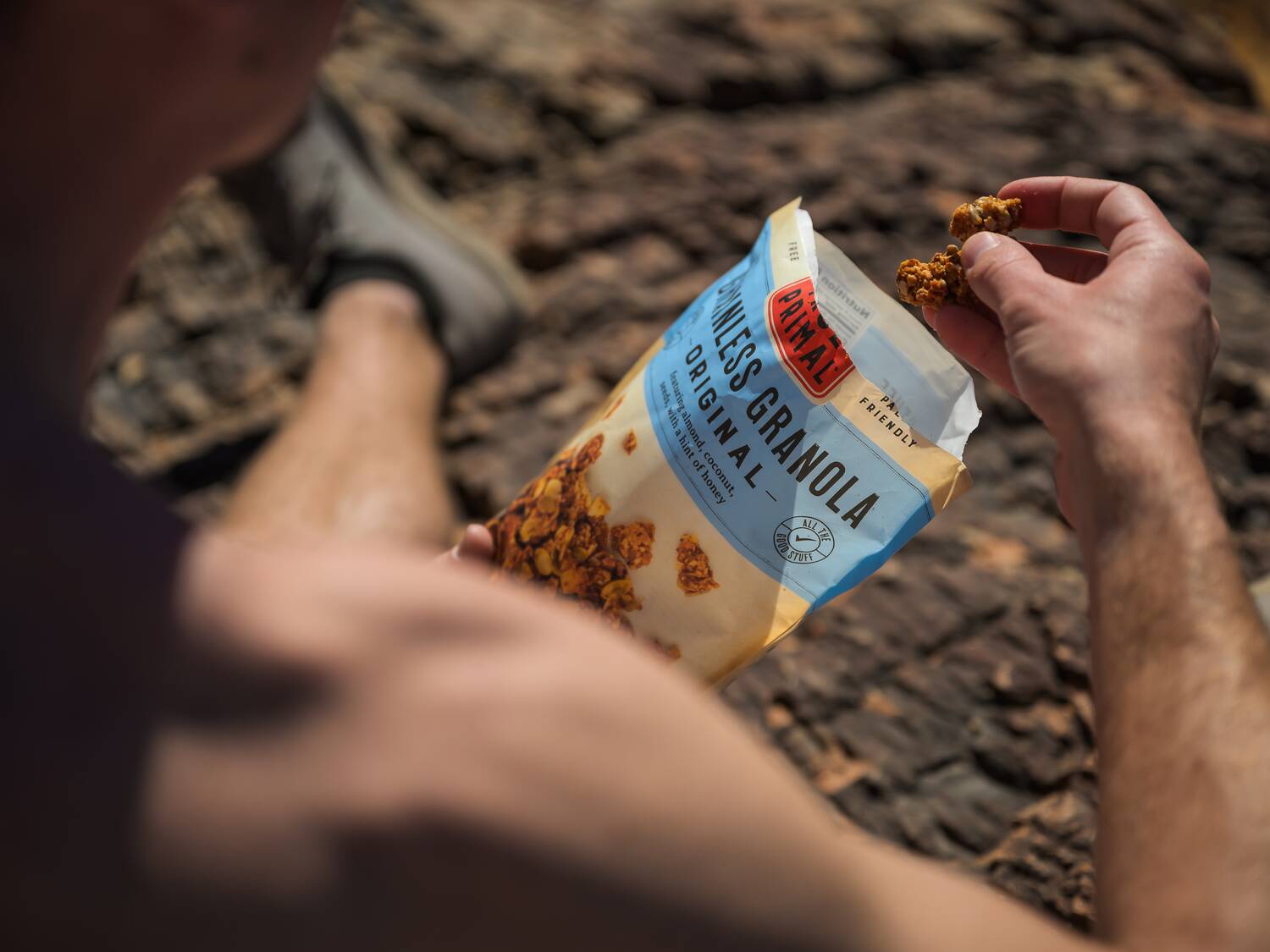 man eating granola from pouch outdoors