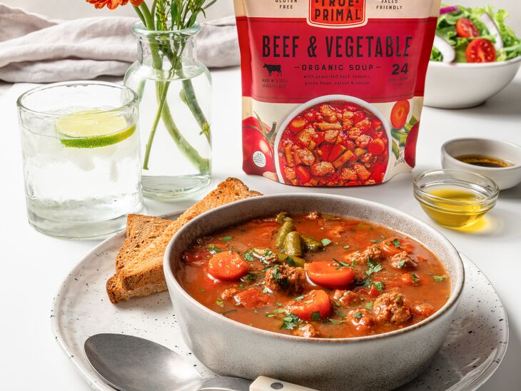 True Primal Beef & Vegetable Organic Soup in bowl with spoon and toast