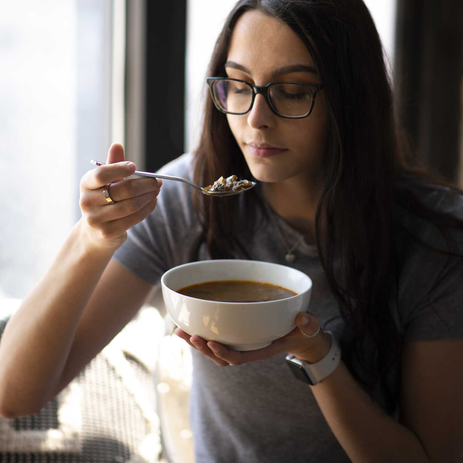 young woman, thinking about savoring soup