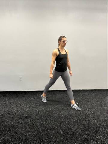 Woman standing with feet hip distance apart and split in a staggered stance.
